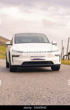 Voiture blanche sur une route rurale sous un ciel nuageux, Tesla, New Model y Juniper, Allemagne, Europe Banque D'Images