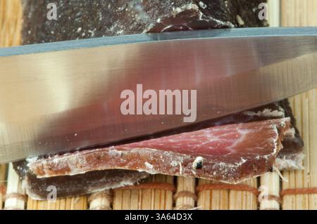 Produits naturels faits de viande séchée de veau. Couper sur une planche en bois Banque D'Images