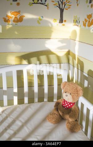 Ours en peluche dans une chambre de bébé. Silhouette de bébé et de mère sur le mur Banque D'Images