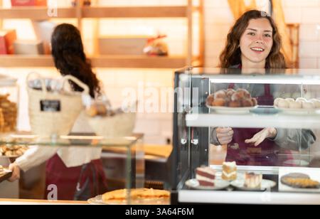 Fille vendeuse travaille dans la boutique de boulangerie cafétéria Banque D'Images