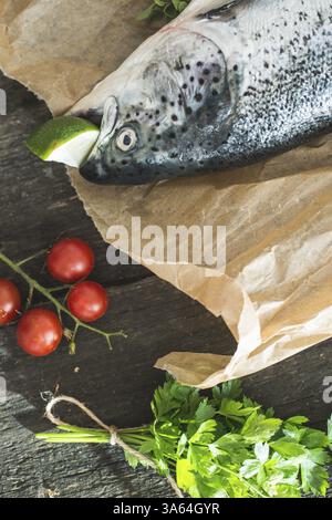 La préparation de poisson saumon entier pour la cuisine. Des légumes sur la table. Style Vintage Banque D'Images