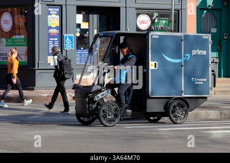 Un livreur dans un vélo cargo électrique à 4 roues Mubea U-Mobility de marque Amazon sur une rue de New York. Le vélo à assistance électrique, ou pedelec ... Banque D'Images