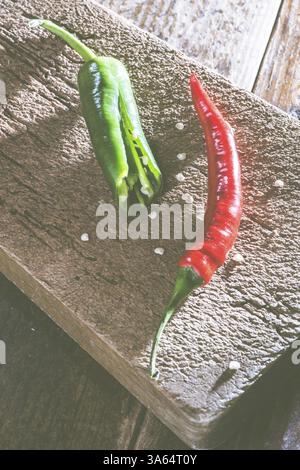 Les piments forts sur la planche à découper de cuisine en bois Banque D'Images