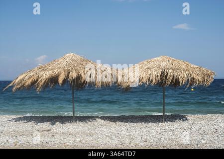 Parasols en paille sur la plage. Grèce Banque D'Images