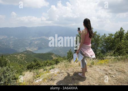 Femme à prendre des photos avec le smartphone dans la forêt Banque D'Images