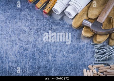 Dessins de construction marteau gants de sécurité en bois mètres clous métalliques et tas de chevilles sur le concept d'entretien de surface métallique rayée Banque D'Images