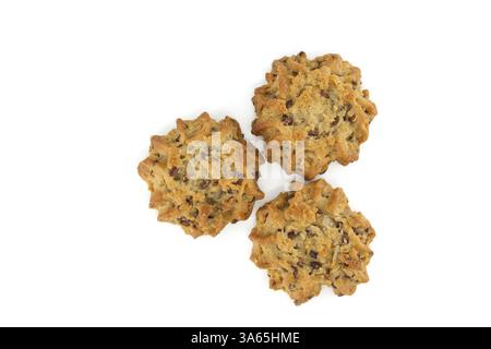 Trois biscuits brun doré avec des pépites de chocolat et des graines de lin, photographiés d'en haut sur un fond blanc. Banque D'Images