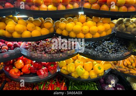 Un affichage coloré de fruits et légumes frais dans un magasin. Pommes, oranges, poivrons, raisins, kiwis, carottes, tomates et chou Banque D'Images