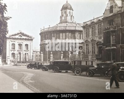 Oxford, Oxfordshire, Angleterre : architecture historique de l'Université d'Oxford. Le bâtiment en forme de dôme est la Radcliffe Camera, l'un des monuments les plus emblématiques d'Oxford. Autour de lui se trouvent des parties de la Bodleian Library, une pièce maîtresse du patrimoine académique d'Oxford. Sur la route à côté de ces bâtiments se trouve une rangée de voitures à moteur. D'après un album de photographies non datées des années 1920, principalement de la mode britannique et de l'histoire sociale. Les photos originales étaient principalement d'environ 3x2 pouces, ton sépia, et prises par un bon photographe amateur. Banque D'Images
