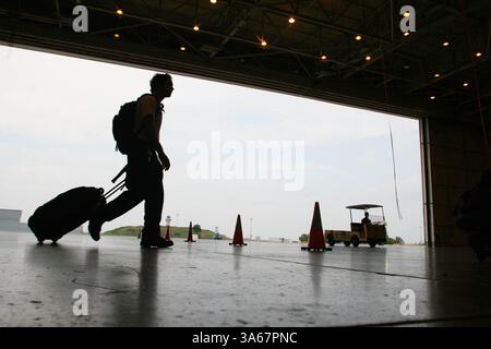 30 août 2008 - David Bridges, un membre paramédical de TX-4 DMAT (Disaster Medical assistance Team) de Denton, remorque ses bagages à un endroit où dormir dans le hangar, préparé pour une nuit très tard où il traite des évacués médicaux à l'aéroport DFW. Les équipes préparaient des berceaux pour se reposer avant une heure incertaine d'arrivée tôt le dimanche matin. TX-4 DMAT est une équipe composée d'experts médicaux DFW, d'infirmières, d'ambulanciers paramédicaux et de médecins. Lorsqu'ils sont activés, ils sont une unité fédérale rattachée au US public Health Service. Les équipes médicales se rassemblent à l'aéroport DFW dans le hangar 5 d'American Airlines, samedi août Banque D'Images