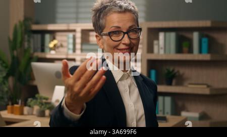 Dans le bureau femme caucasienne entreprise femme d'affaires mature employeur senior vieux recruteur d'âge moyen pointant le doigt à la caméra en face hé vous Banque D'Images