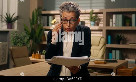 Au bureau en colère fou vieux caucasien femme d'affaires femme d'affaires femme d'affaires mature employeur senior moyen-Age PDG entrepreneur parlant appel de téléphone mobile Banque D'Images