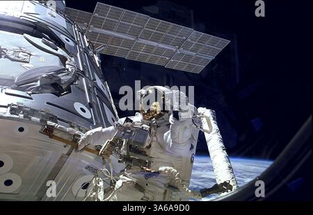 Dec. 5, 2014 - célébration des quinze ans de la Station spatiale internationale. L'astronaute James H. Newman fait des vagues lors d'une sortie dans l'espace qui se prépare à la sortie des premiers éléments combinés de la Station spatiale internationale. Le module Zarya de construction russe, avec son panneau solaire visible ici, a été lancé en orbite il y a quinze ans, le 20 novembre 1998. Deux semaines plus tard, le 4 décembre 1998, la navette spatiale Endeavour de la NASA lance Unity, la première pièce américaine du complexe. La section avant d'Endeavour est reflétée dans la visière du casque de Newman sur cette image. Au cours de trois sorties dans l'espace de la mission STS-88, le Banque D'Images