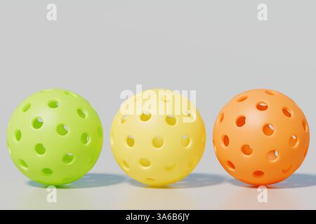 Boules de pickleballs en plastique colorées en vert, jaune et orange sur un fond gris. rendu 3d. Banque D'Images