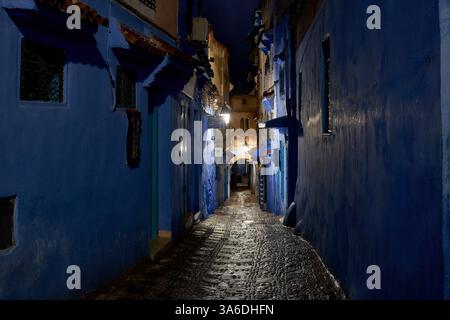 Une belle rue vide illuminée la nuit dans la vieille ville aux murs bleus, Chefchaouen, Maroc Banque D'Images