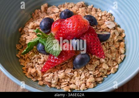 Gros plan bol de granola de petit déjeuner avec fraises fraîches et bleuets Banque D'Images