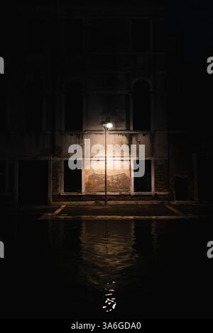 Lampe éclairant une vieille façade sur une rue de Venise Banque D'Images