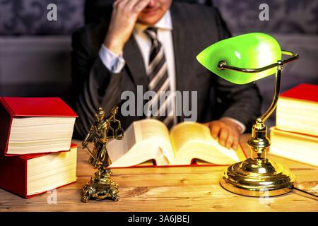 Bureau d'un avocat avec des livres et une statue de Dame Justice, déesse Justitia, sur le bureau Banque D'Images
