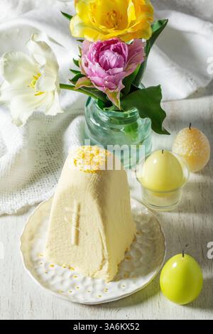 Plat traditionnel de Pâques slaves à base de fromage cottage - Paskha, un bouquet de tulipes et de bougies sur un fond clair. Style rustique, mise au point sélective Banque D'Images