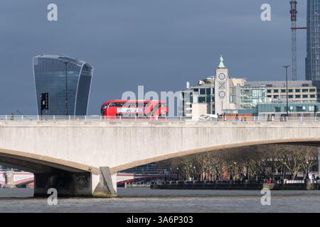 Bus rouge traversant Waterloo Bridge sur la Tamise avec la ville de Londres vue depuis Victoria Embankment, Londres, Angleterre, Royaume-Uni Banque D'Images