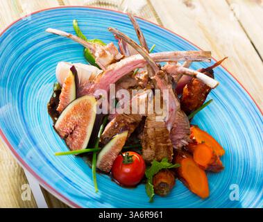 Côtes d'agneau cuites avec légumes, figues, demi-glace de sauce Banque D'Images