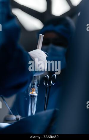 Chirurgien pratiquant une opération cardiaque à pleine concentration dans une salle d'opération bien éclairée. Médecin professionnel. Technologies, cardiologie. Banque D'Images