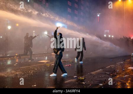 Ankara, Turquie. 26 mars 2025. Une protestataire résiste pendant l'intervention du canon à eau. Les manifestations qui ont commencé après l'arrestation du maire métropolitain d'Istanbul, Ekrem Imamoglu, du Parti républicain du peuple (CHP), le 23 mars, se poursuivent dimanche. La police a empêché la marche de la messe réunie sur la place K ?z ?Lay et l'Université du moyen-Orient (ODTU) à Ankara. Crédit : SOPA images Limited/Alamy Live News Banque D'Images