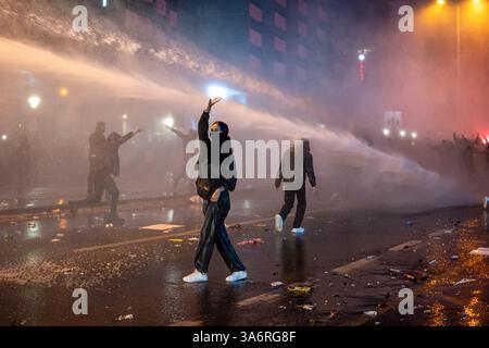 Ankara, Turquie. 26 mars 2025. Une protestataire résiste pendant l'intervention du canon à eau. Les manifestations qui ont commencé après l'arrestation du maire métropolitain d'Istanbul, Ekrem Imamoglu, du Parti républicain du peuple (CHP), le 23 mars, se poursuivent dimanche. La police a empêché la marche de la messe réunie sur la place K ?z ?Lay et l'Université du moyen-Orient (ODTU) à Ankara. (Photo de Tunahan Turhan/SOPA images/Sipa USA) crédit : Sipa USA/Alamy Live News Banque D'Images