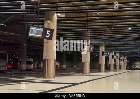 Une station de bus vide à l'intérieur avec des bus stationnés et de grandes colonnes Banque D'Images