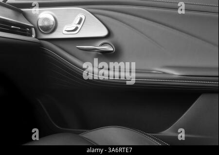 Poignée de porte avec boutons de commande de siège électrique d'une voiture de tourisme. Intérieur en cuir noir de voiture moderne. Détails de l'intérieur de la voiture Banque D'Images