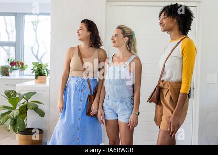 Trois amies souriantes et appréciant le temps ensemble à la maison Banque D'Images
