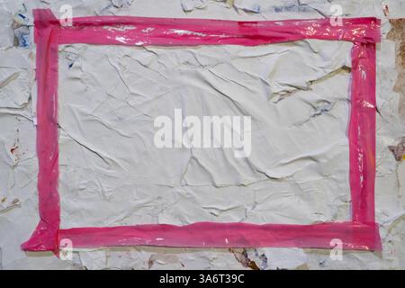 Cadre rectangulaire en ruban plastique rose sur texture d'affiche Wheatpaste Banque D'Images