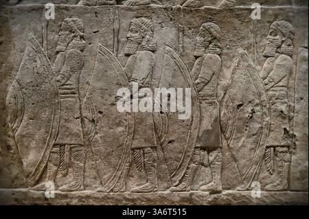 Panneau de sculpture en relief assyrien de soldats de fer de lance bordant la route de la chasse au lion du roi Ashurnasirpal. Du Palais Nord de Ninive, Irak, 668-62 Banque D'Images