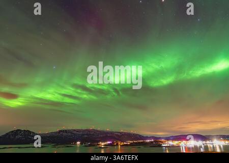 Belle Aurora Borealis sur la maison sur l'île de Kvaløya, dansant les aurores boréales avec la lumière verte, les grèves rouges et violettes, les rayons colorés clairs Banque D'Images
