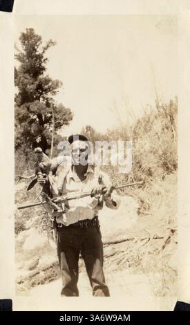 12 décembre 2014 - CANADA - VERS 1940 : reproduction d'une photo antique montrant un chasseur avec une arme à feu tuant des chevreuils sur ses épaules posant sur un fond de forêt (crédit image : © Igor Golovniov/ZUMA Wire/ZUMAPRESS.com) Banque D'Images