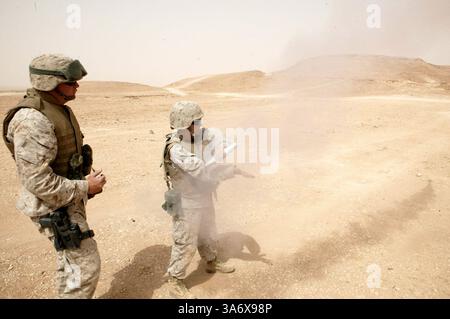 10 juillet 2004 ; Al Asad, Irak ; le sergent d'artillerie ERIC DICKERSON, chef de garde, Force de sécurité du centre de commandement aérien tactique, escadron 3 du quartier général de l'escadre des Marines, 3e escadre d'avion des Marines, et natif d'Atlanta âgé de 35 ans, supervise le Cpl NORA G. FORSYTHE, garde, Force de sécurité du TACC, MWHS-3, alors qu'elle lance une fusée éclairante d'étoiles blanches à Al Asad, Irak, le 10 juillet. La jeune fille de 21 ans de Charlotte, en Caroline du Nord, a tiré de nombreuses armes pour la première fois lorsqu’elle a attaqué le tir de combat et le parcours de manœuvre ici. Banque D'Images