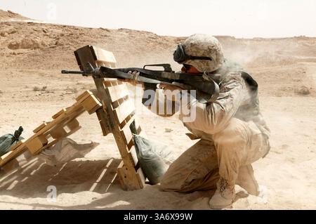 10 juillet 2004 ; Al Asad, Irak ; Un nuage de poussière provenant du recul de son fusil de service M-16A2 entoure le Cpl KIP M. MADDOX, garde, Force de sécurité du Centre de commandement aérien tactique, escadron 3 du quartier général de l'escadre des Marines, 3e escadre d'avion des Marines, à Al Asad, Irak, alors qu'il vise une cible de son côté faible, le 10 juillet. Le natif d'Enid, Oklahoma, 24 ans, était l'un des nombreux Marines des forces de sécurité qui ont suivi une formation sur le tir et les manœuvres pour rafraîchir leurs compétences de combat. Banque D'Images