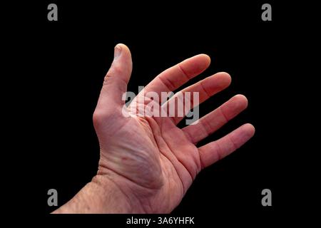 Homme adulte blanc main sur fond noir en contraste élevé Banque D'Images