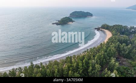 C'est une belle image de coucher de soleil sur l'océan, avec une petite île ou masse terrestre au premier plan. Les teintes dorées du soleil se fondent harmonieusement en t Banque D'Images