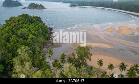 C'est une belle image de coucher de soleil sur l'océan, avec une petite île ou masse terrestre au premier plan. Les teintes dorées du soleil se fondent harmonieusement en t Banque D'Images