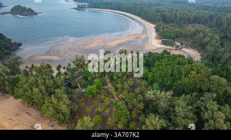 C'est une belle image de coucher de soleil sur l'océan, avec une petite île ou masse terrestre au premier plan. Les teintes dorées du soleil se fondent harmonieusement en t Banque D'Images