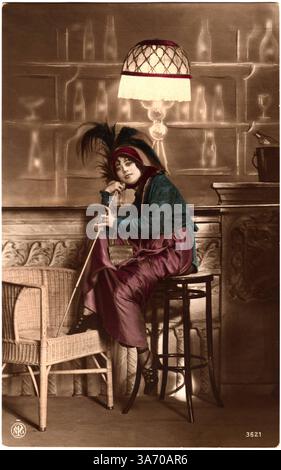 27 août 2014 - 'femme souriante portant un chapeau Plume assis sur un tabouret de bar et tenant une canne à pied, carte postale colorée à la main, circa 1910'' (crédit image : © Glasshouse/ZUMA Wire) Banque D'Images