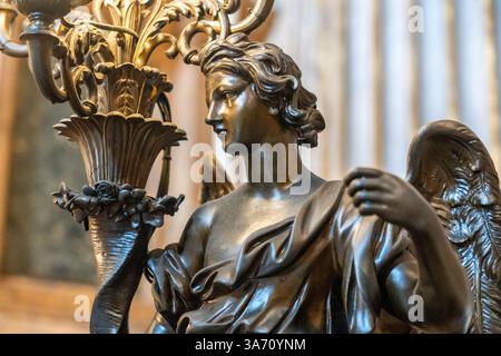 Gros plan sur la statue en bronze d'un ange tenant un gros bâton de bougie Banque D'Images
