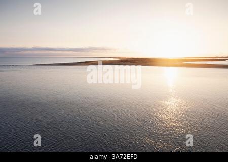 Soleil levant reflété dans la surface calme de la mer Banque D'Images