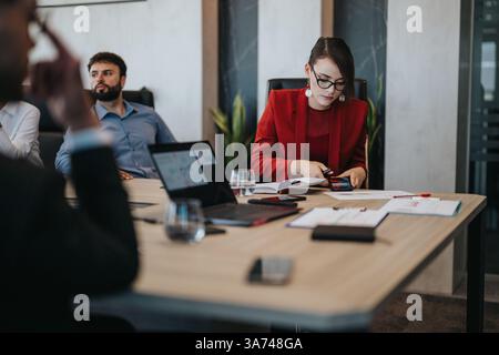 Réunion d'affaires multiculturelle avec une femme focalisée en blazer rouge Banque D'Images