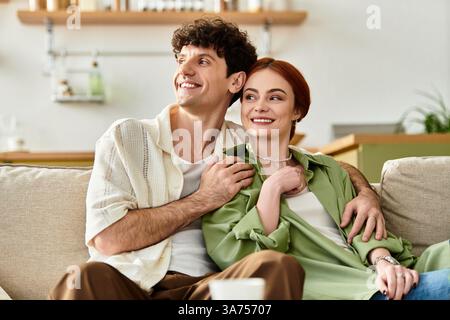 Un couple heureux profite de moments joyeux ensemble sur leur canapé confortable à la maison. Banque D'Images