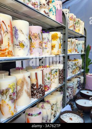 Un stand avec des bougies aromatiques design en cire blanche et de belles fleurs séchées, fabriquées à la main Banque D'Images