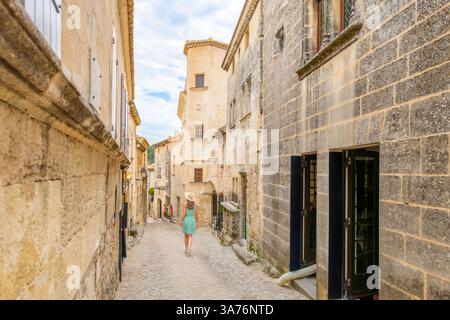 Une jeune femme descend une ruelle pavée dans le centre médiéval du village français des Baux de Provence, en France. Banque D'Images