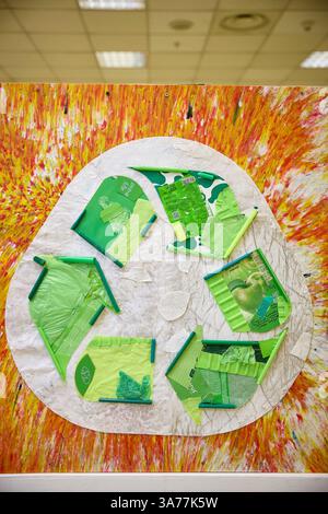 Nature morte créative, fragments d'emballage vert éclatant disposés sur du papier texturé sur un fond coloré et abstrait, évoquant des thèmes de recyclage, Banque D'Images
