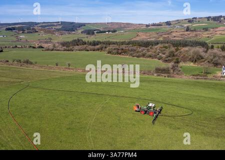 L'agriculteur épand le lisier à l'aide d'un système de pompe ombilicale et d'une barre d'égouttement. Drinagh, West Cork, Irlande. Banque D'Images
